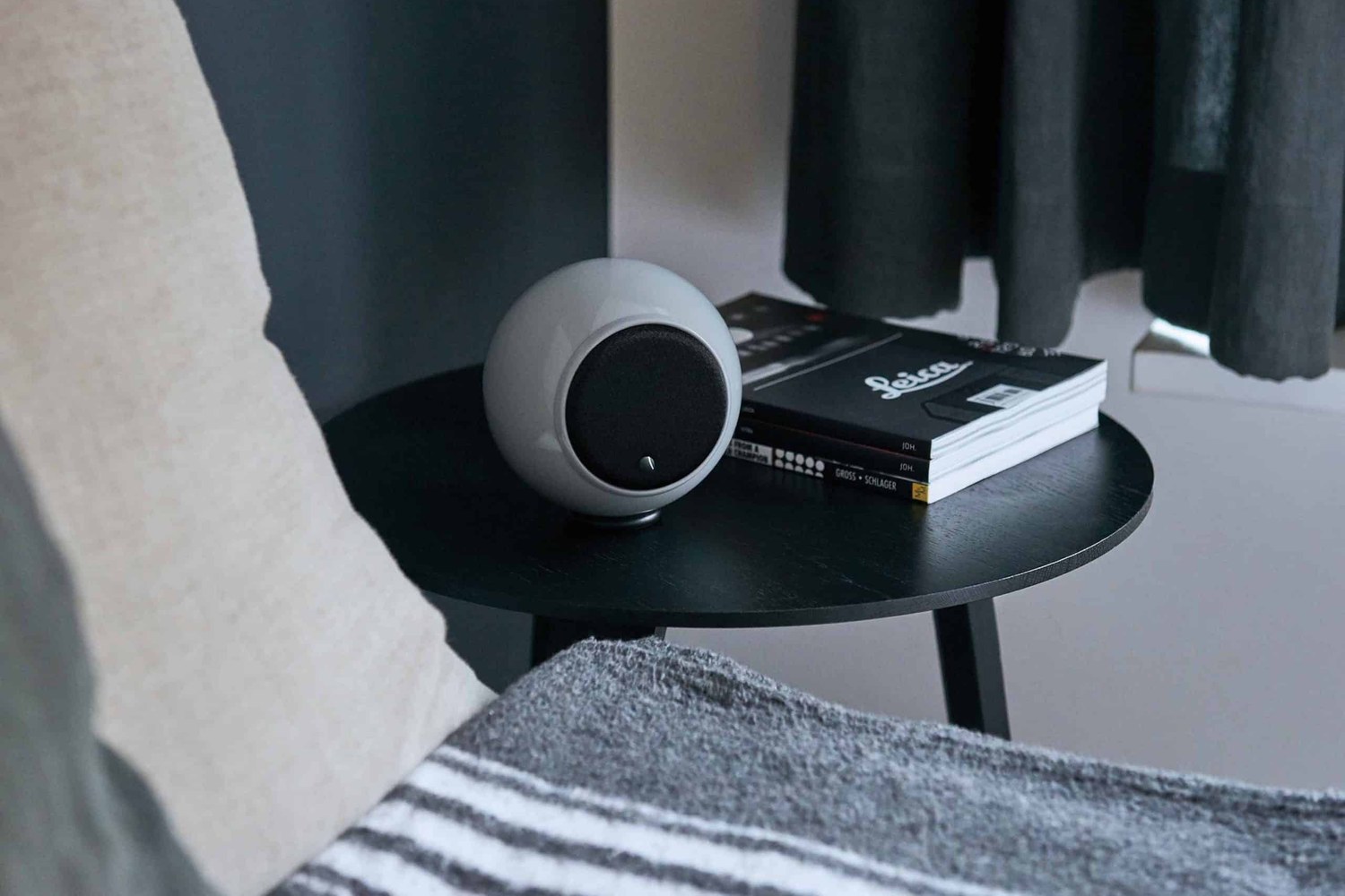 Enceinte grise sur une table d'appoint près d'un canapé