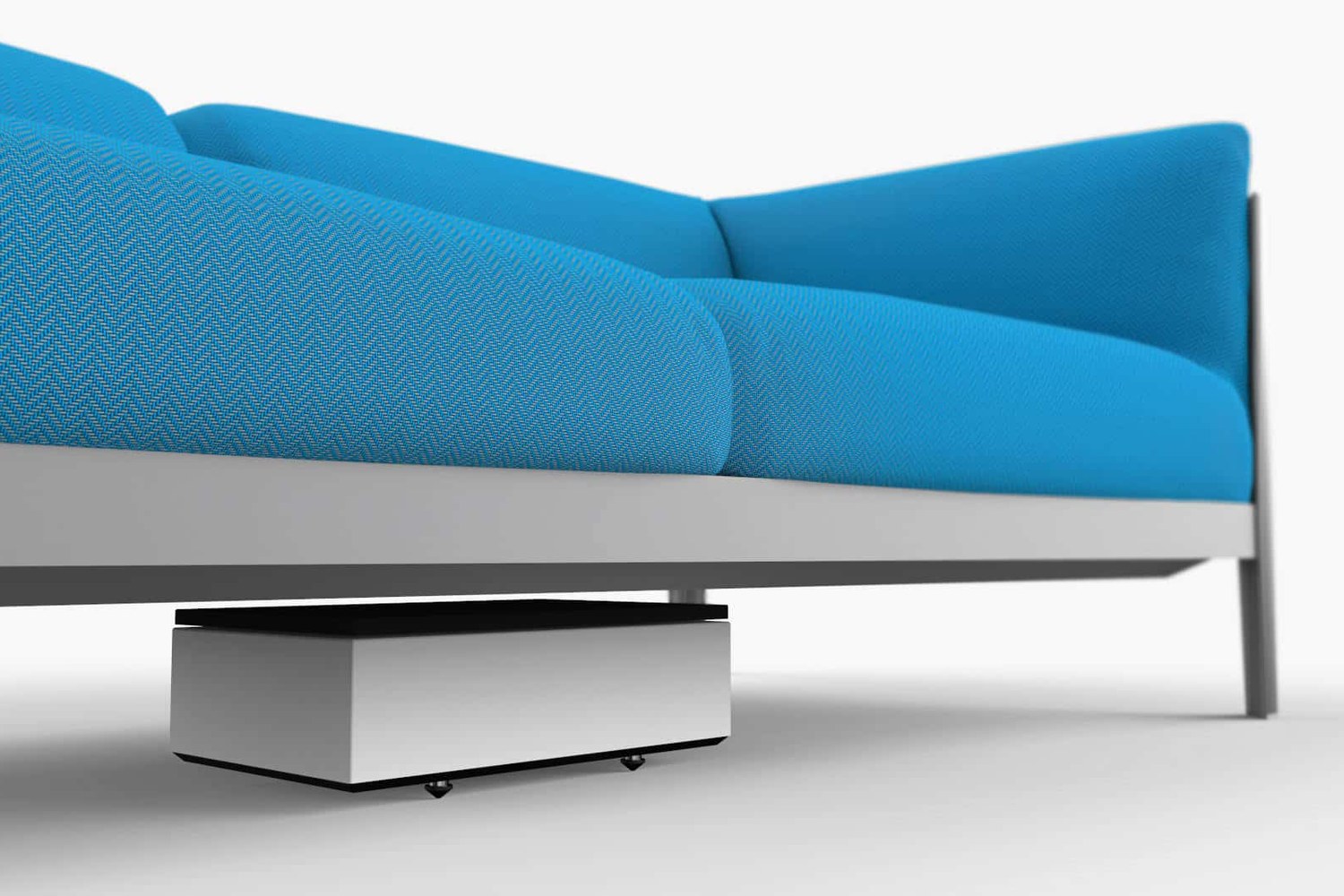 White subwoofer slid under a blue sofa