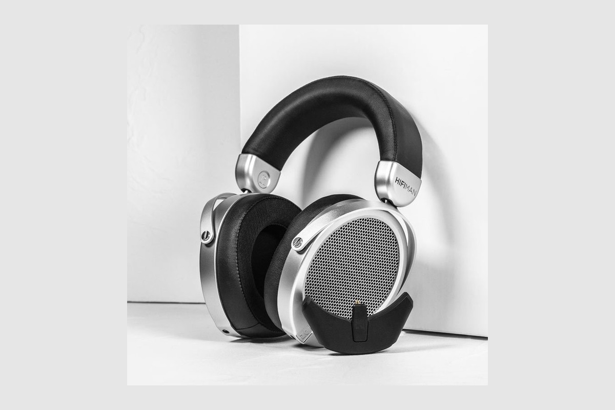 Headphones resting on the floor against a white wall