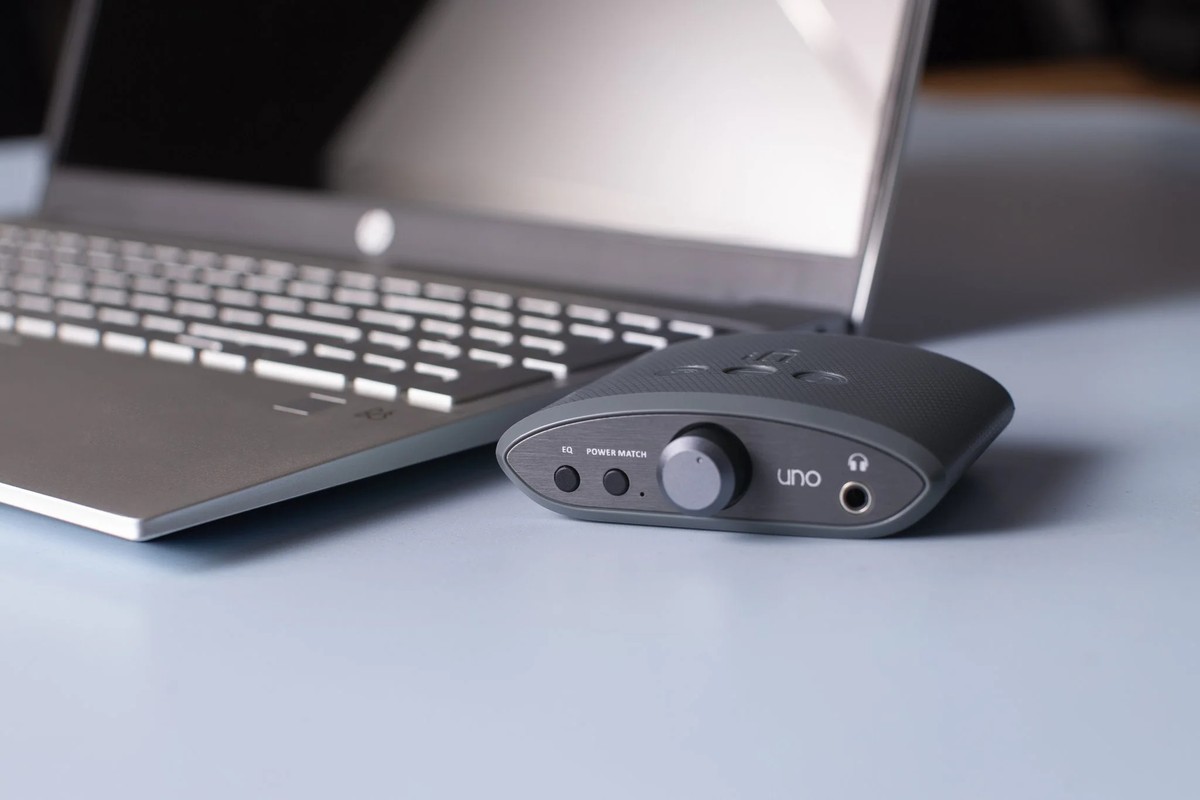 Anthrazitgraues Gerät vor einem aufgeklappten Laptop