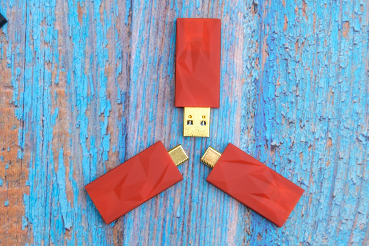 Three versions of the orange adapter on blue-painted wood