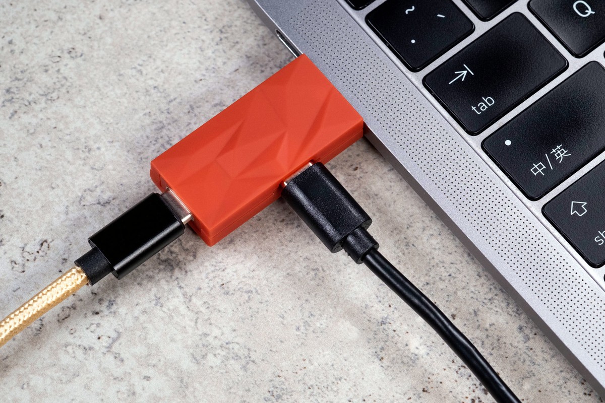 Orange iDefender+ in USB-C on a laptop, gold braided cable