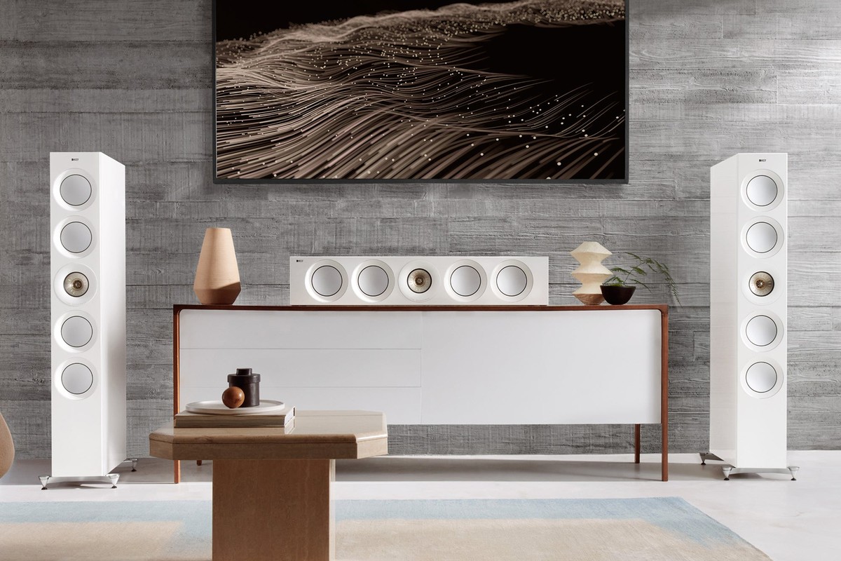 Enceinte centrale KEF Reference 4 Meta sous un téléviseur, entre deux colonnes
