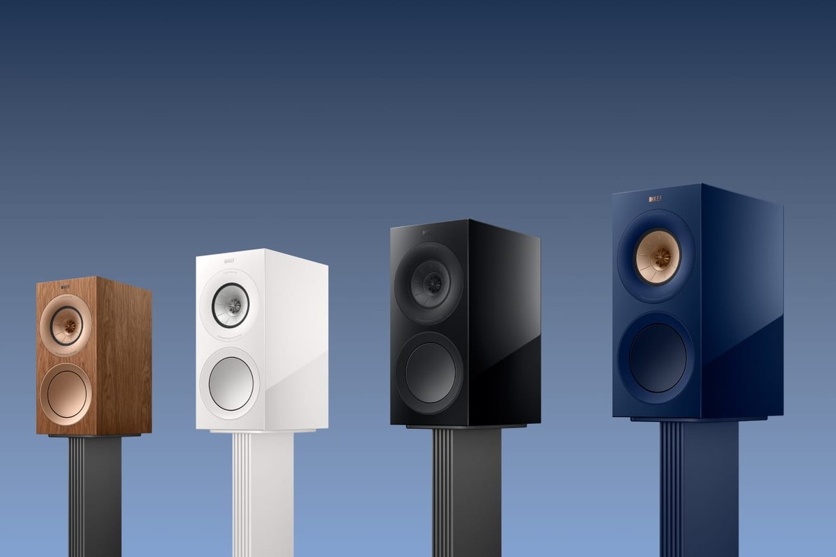 Four speakers on their stands, wood, white, black and blue finishes
