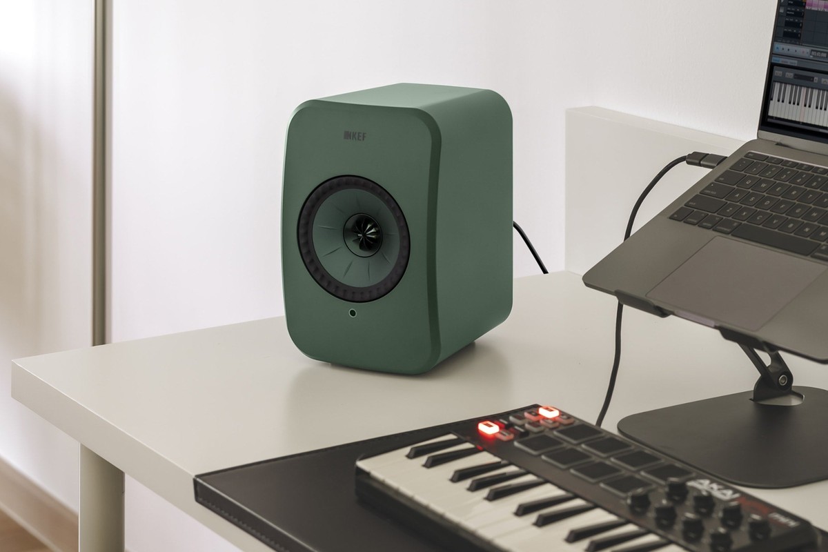 KEF LSX II LT vert sauge sur un bureau près d'un ordinateur