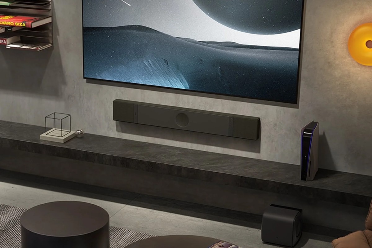 Barre de son KEF XIO noire installée sous un téléviseur mural