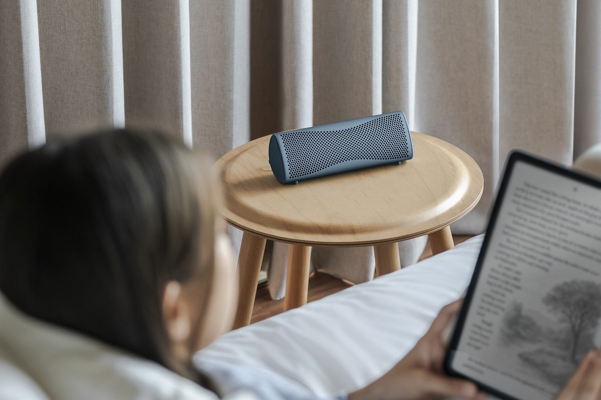Enceinte sur un bureau à côté d'un ordinateur portable