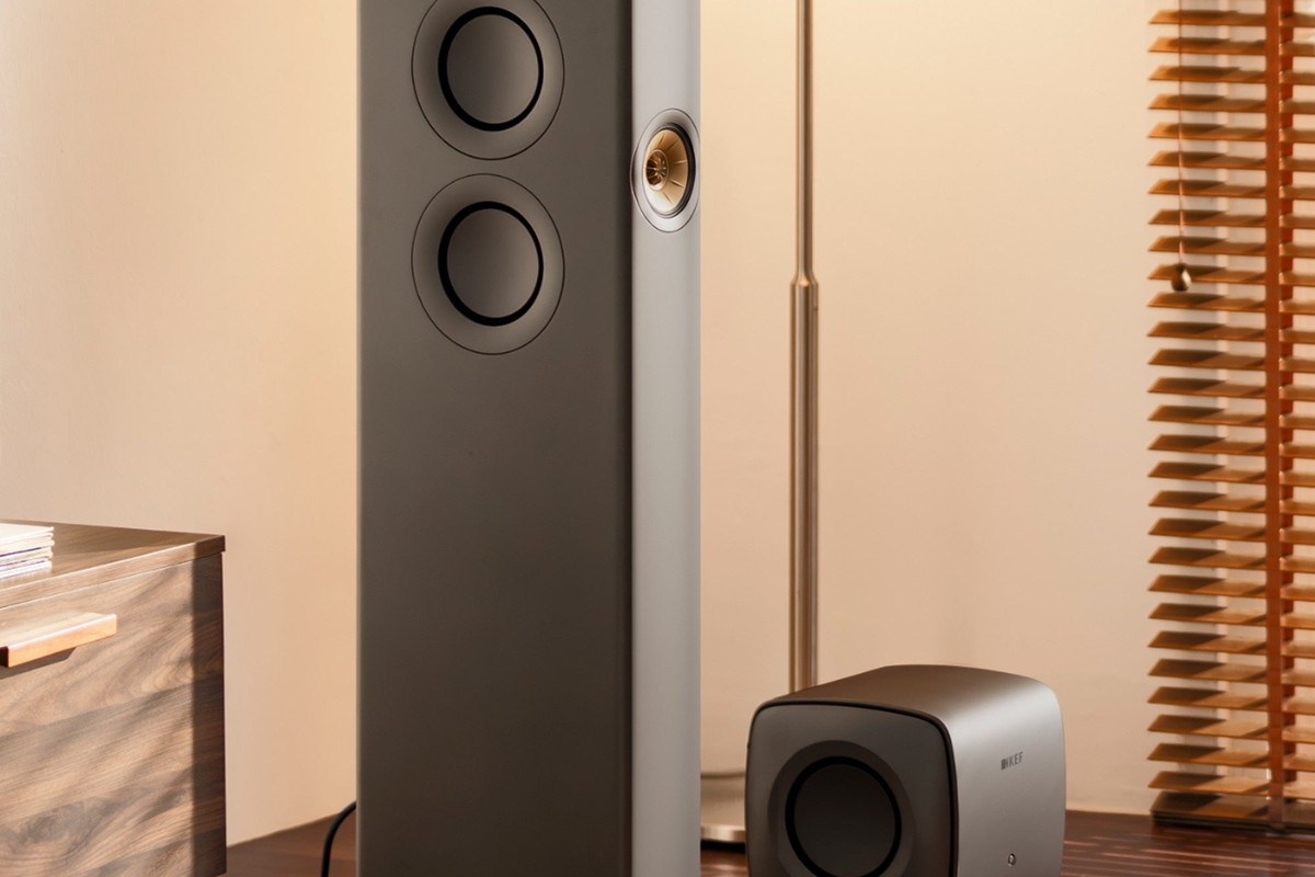 Caisson de basses KEF KC62 gris titane au pied d'une enceinte colonne
