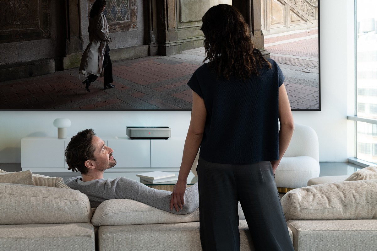 Leica Cine 1 100 inch beneath the large image in a bright living room, couple on the sofa