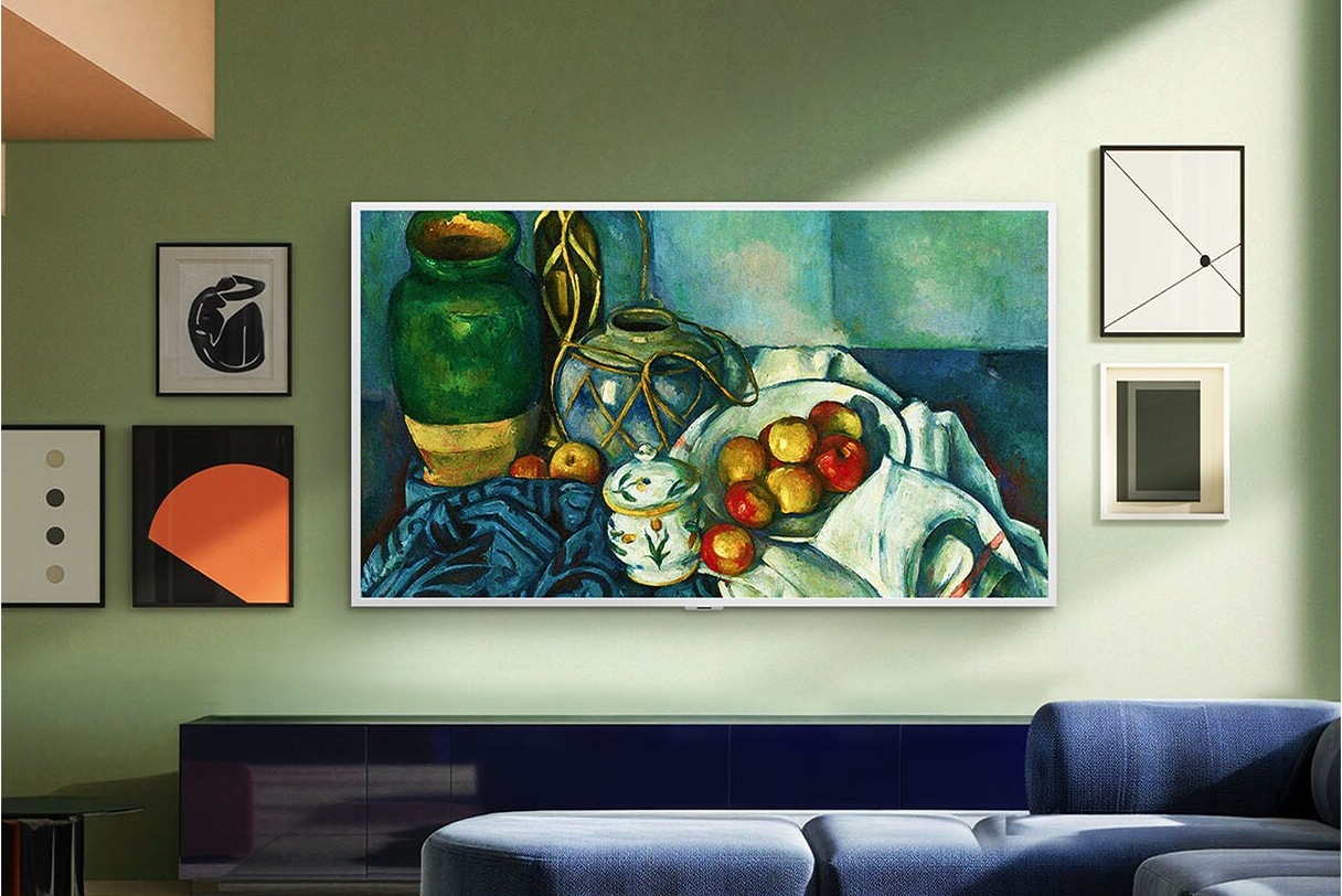 Wohnzimmer in Grüntönen mit einem Fernseher mit weissem Rahmen, der ein Kunstwerk zeigt