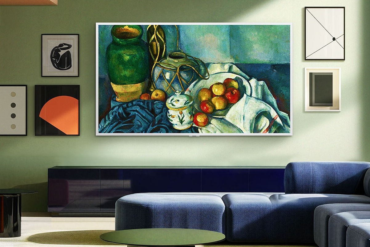 Wohnzimmer in Grüntönen mit einem Fernseher mit weissem Rahmen, der ein Kunstwerk zeigt