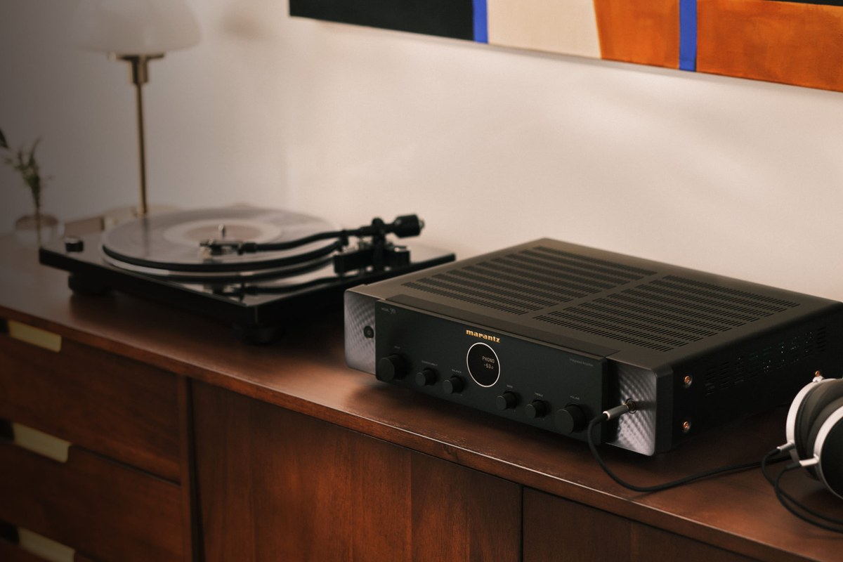 Amplificatore nero su una credenza accanto a un giradischi e a una cuffia