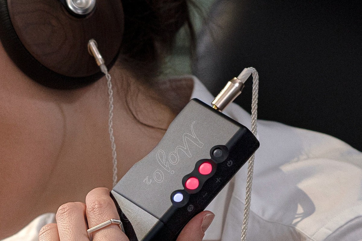 Câble argenté branché entre un casque et un amplificateur portable