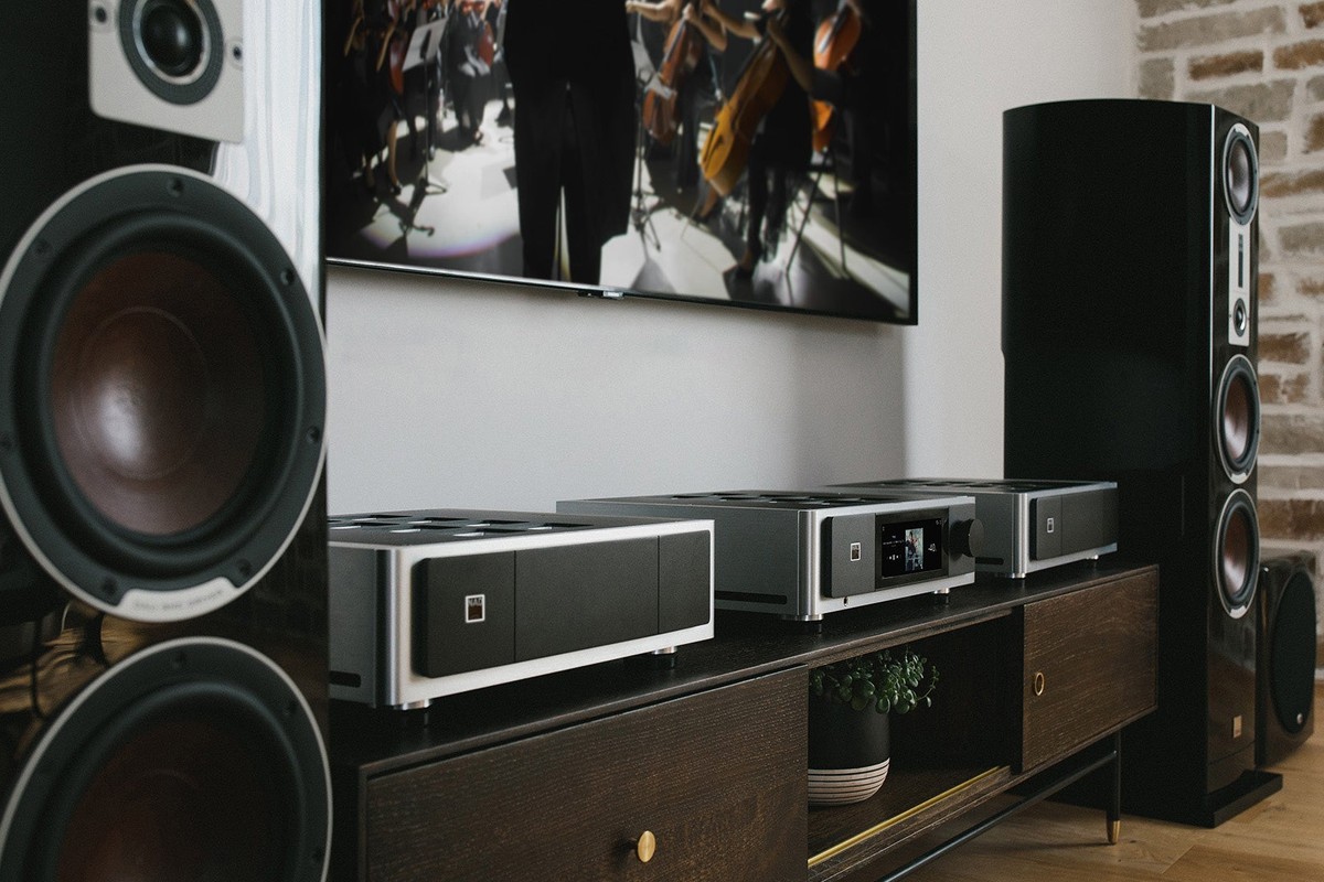 Hi-Fi-Anlage mit zwei Standlautsprechern, einem Subwoofer und drei Geräten auf einem Möbel