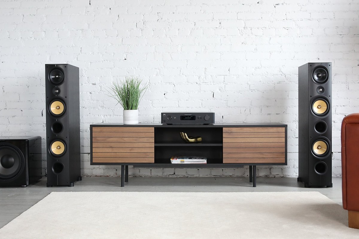 Système hi-fi avec amplificateur NAD C 389 sur un meuble entre deux enceintes colonnes