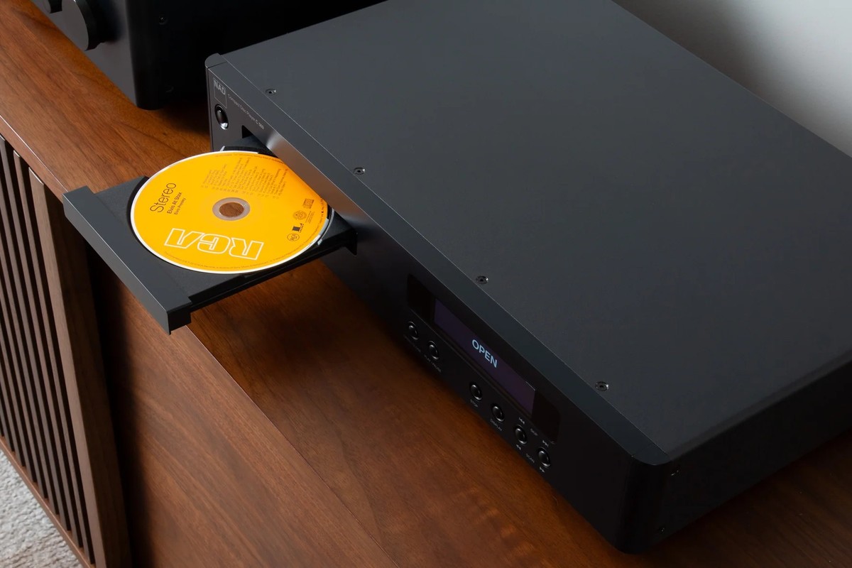 Compact disc nel cassetto aperto del lettore, su un mobile in noce
