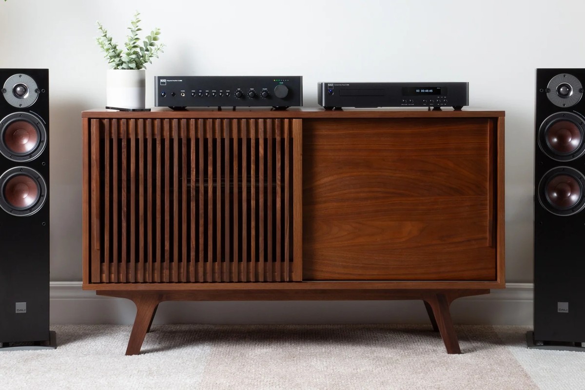 Lettore CD e amplificatore integrato su una credenza, tra due diffusori da pavimento