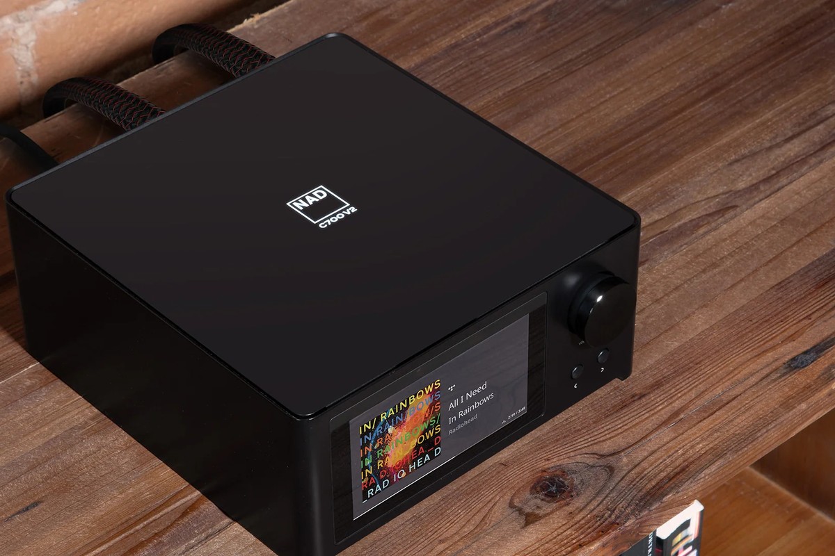 Black amplifier seen from above on a wooden shelf, screen lit