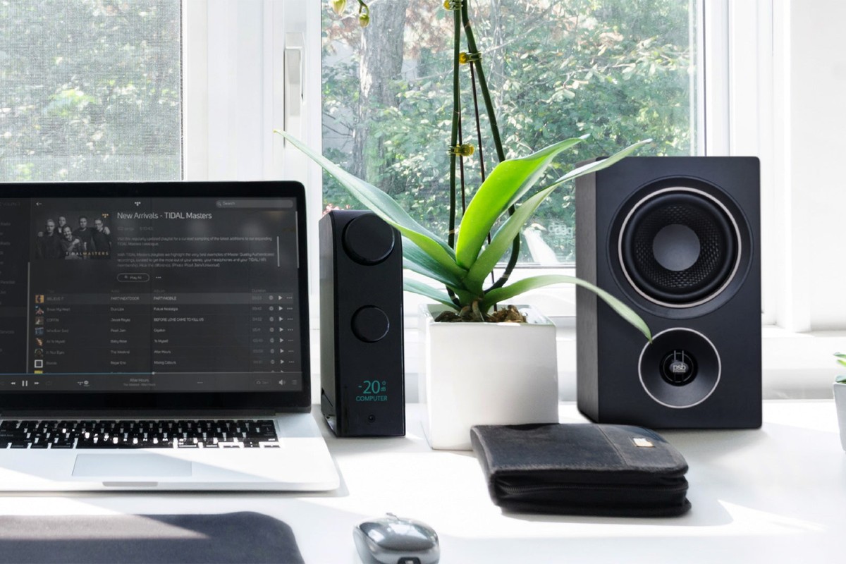 Amplificateur sur un bureau avec ordinateur portable et enceinte bibliothèque