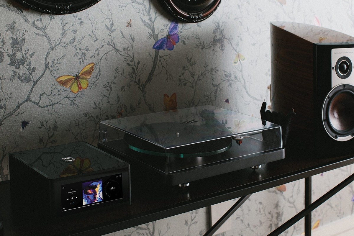 NAD C 588 turntable with closed dust cover next to a network player and a speaker