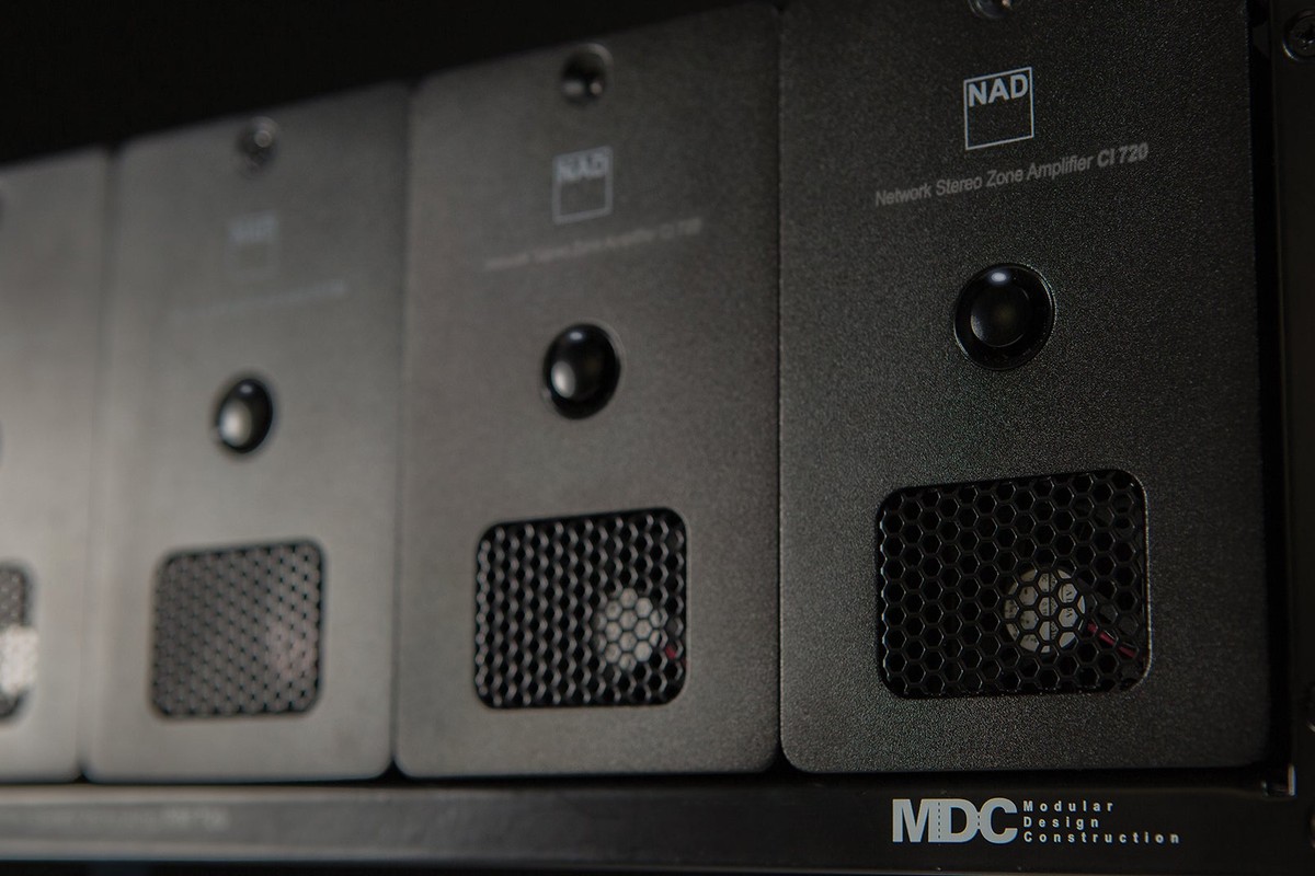 Modules d'amplification noirs alignés dans une baie technique