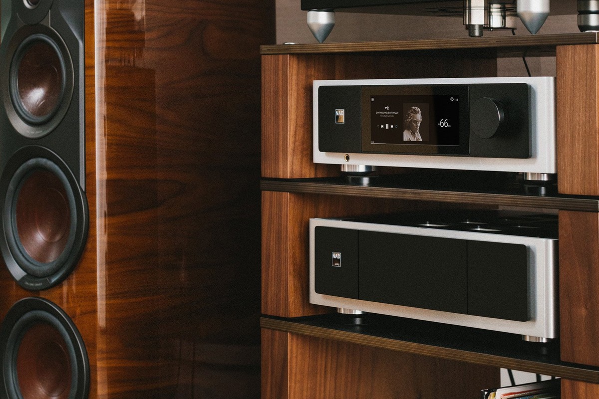 NAD M33 V2 sopra un finale di potenza in un mobile hi-fi in noce