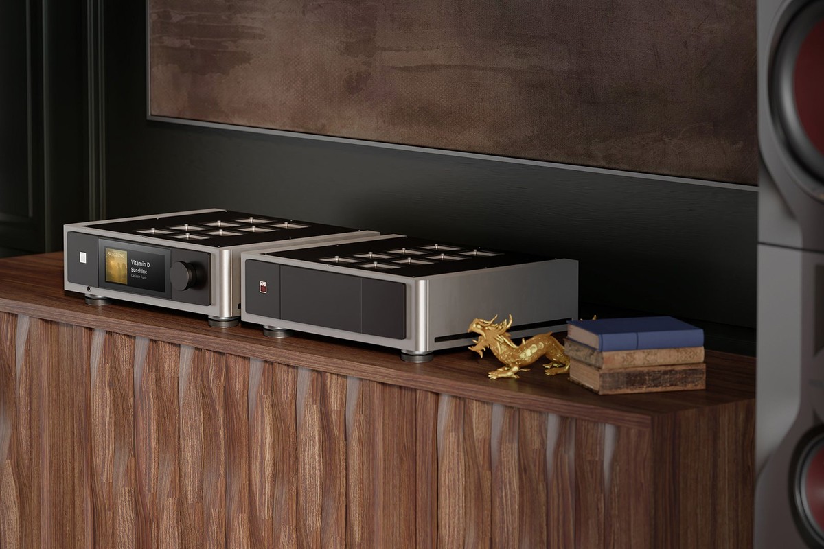 Amplificatore integrato e finale di potenza su una credenza in legno accanto a una statuetta dorata