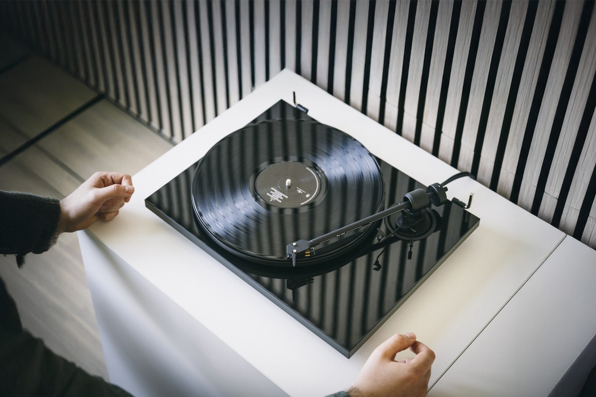 Mains posant une platine noire laquée sur un meuble blanc