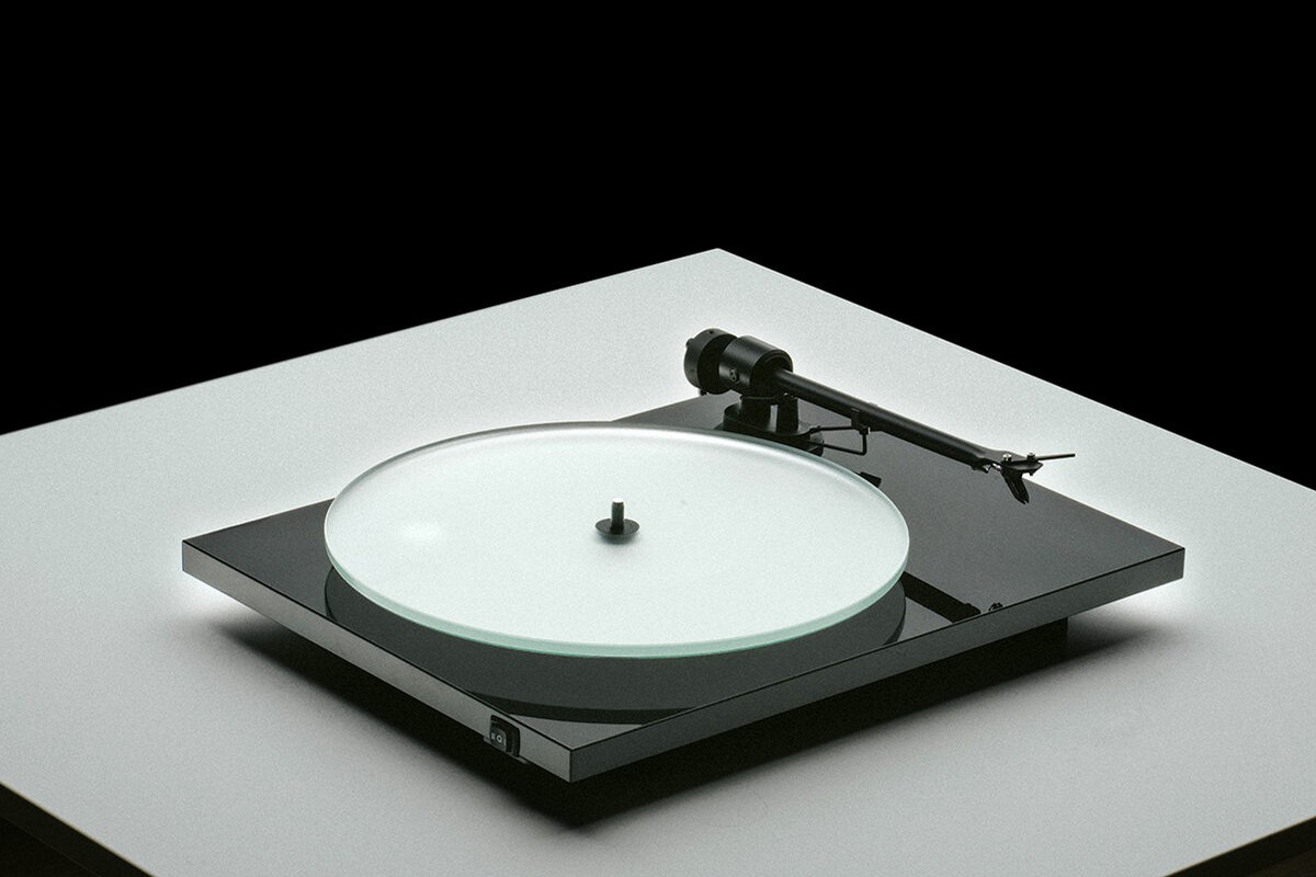 High gloss black turntable with glass platter under studio light
