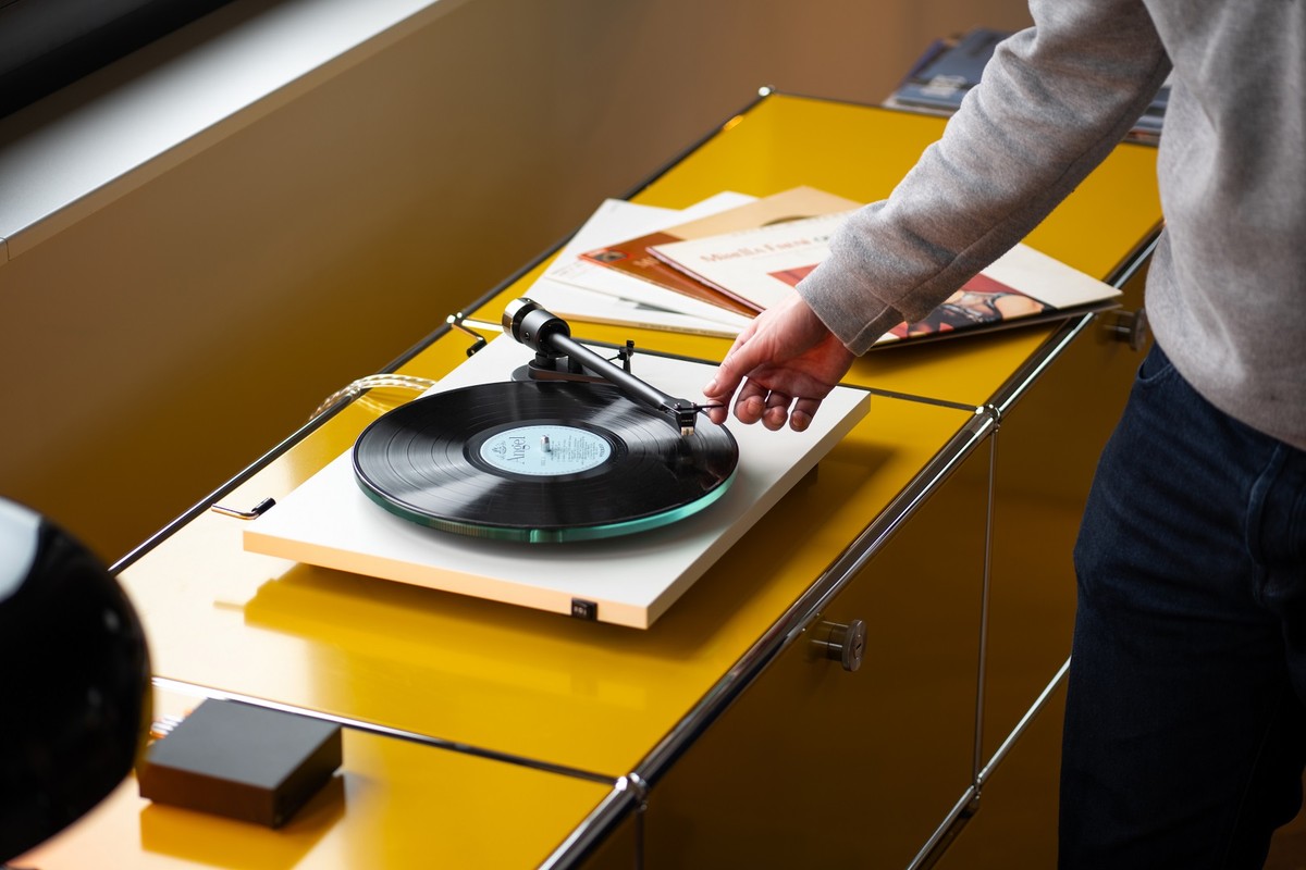 Personne choisissant un disque près d'une platine blanche