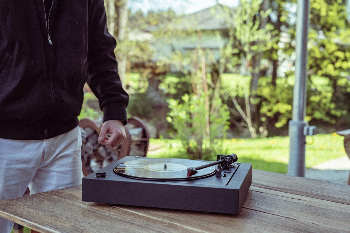 Personne installant une platine sur une table en bois