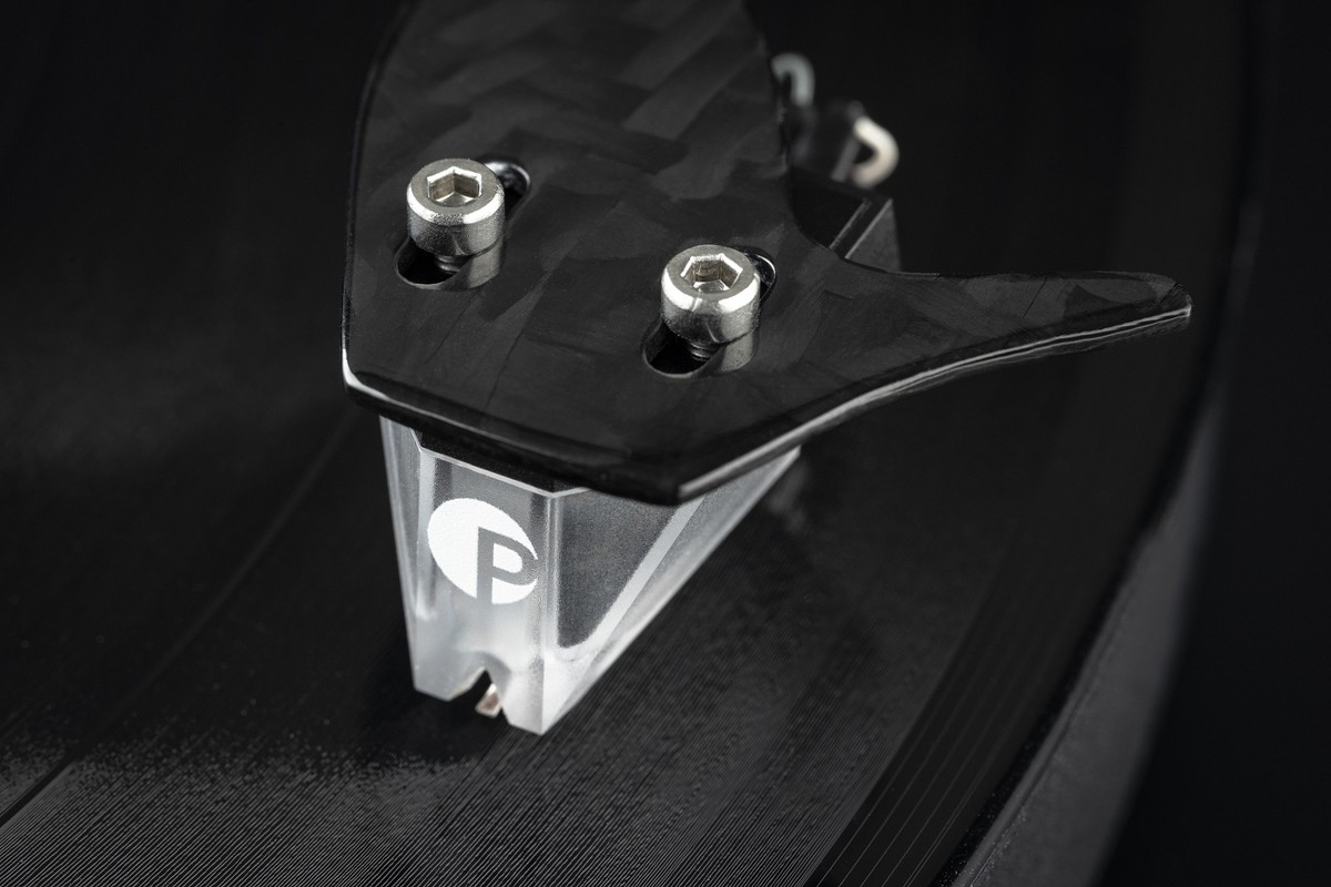 Carbon tonearm and transparent cartridge on a dark background