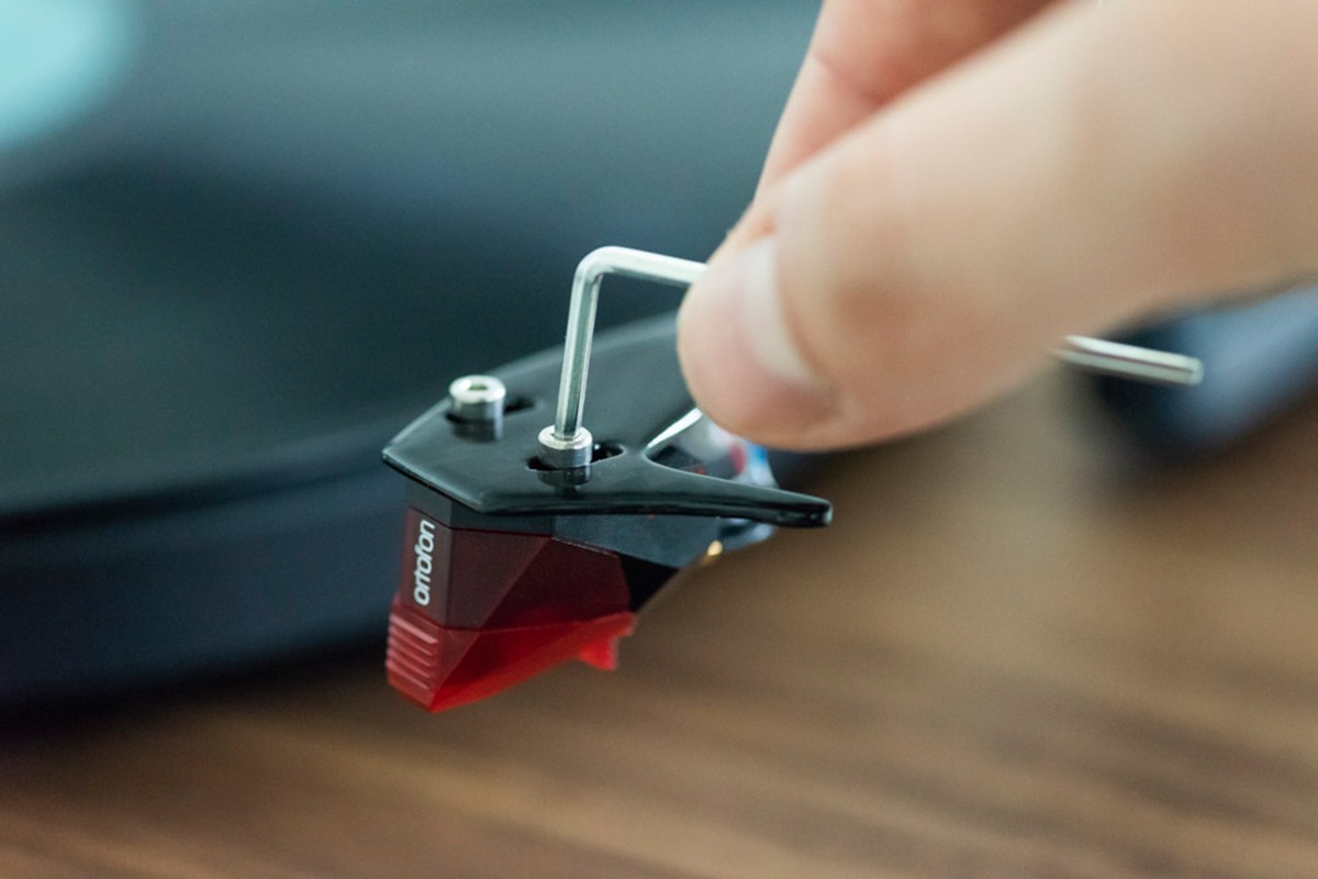 Hand tightening a mounting screw on a red cartridge