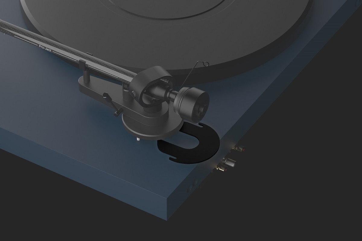 Black spacer fitted under the tonearm base of a blue turntable