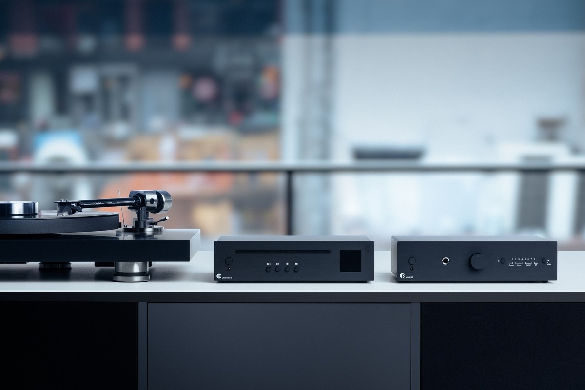 Électroniques noires sur un meuble bas avec une platine vinyle