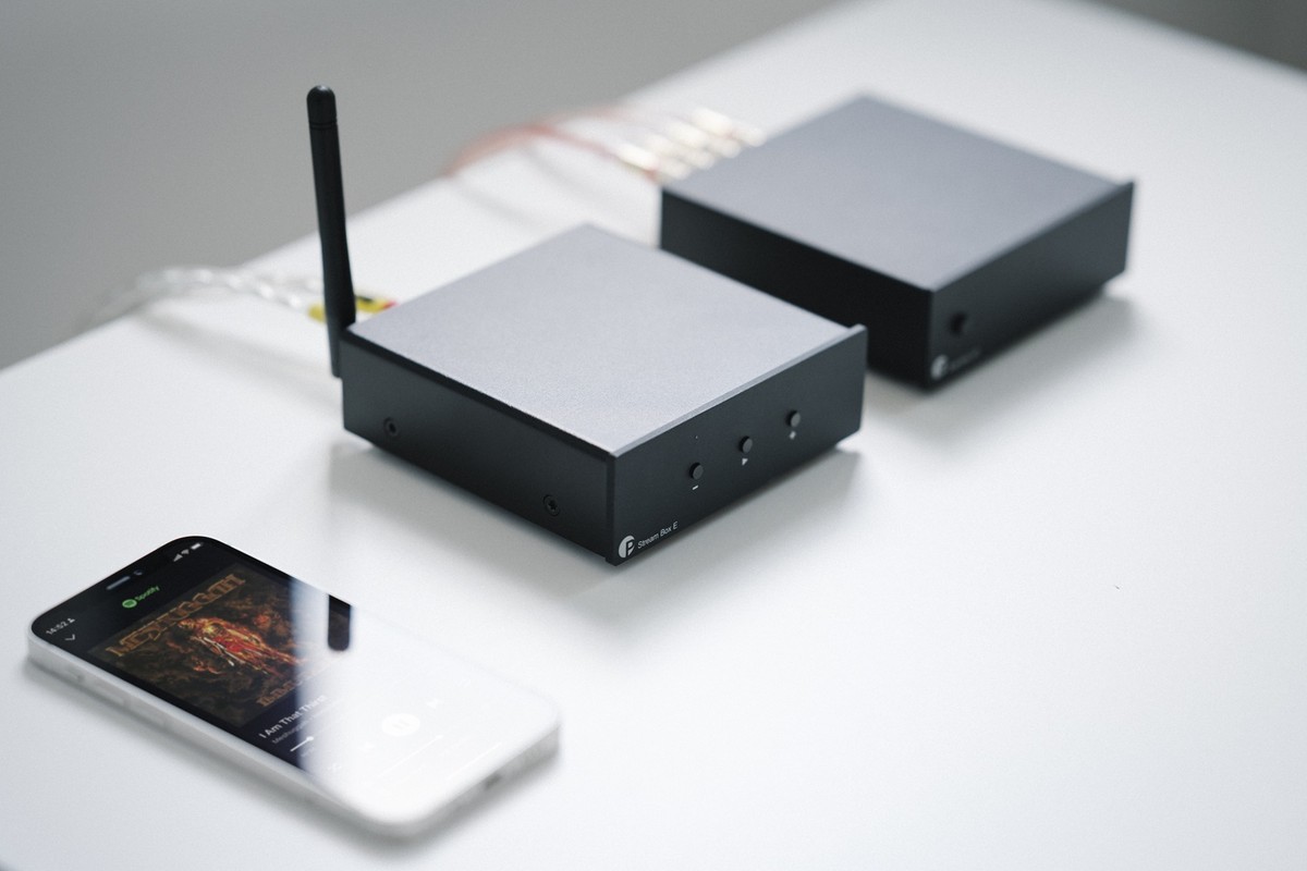Streamer nero accanto a uno smartphone e a un amplificatore