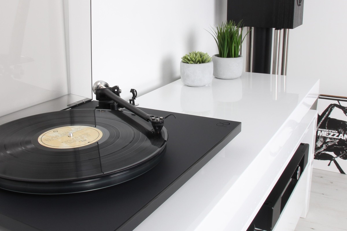 Platine vinyle Rega Planar 6 posée sur un meuble, vue trois quarts