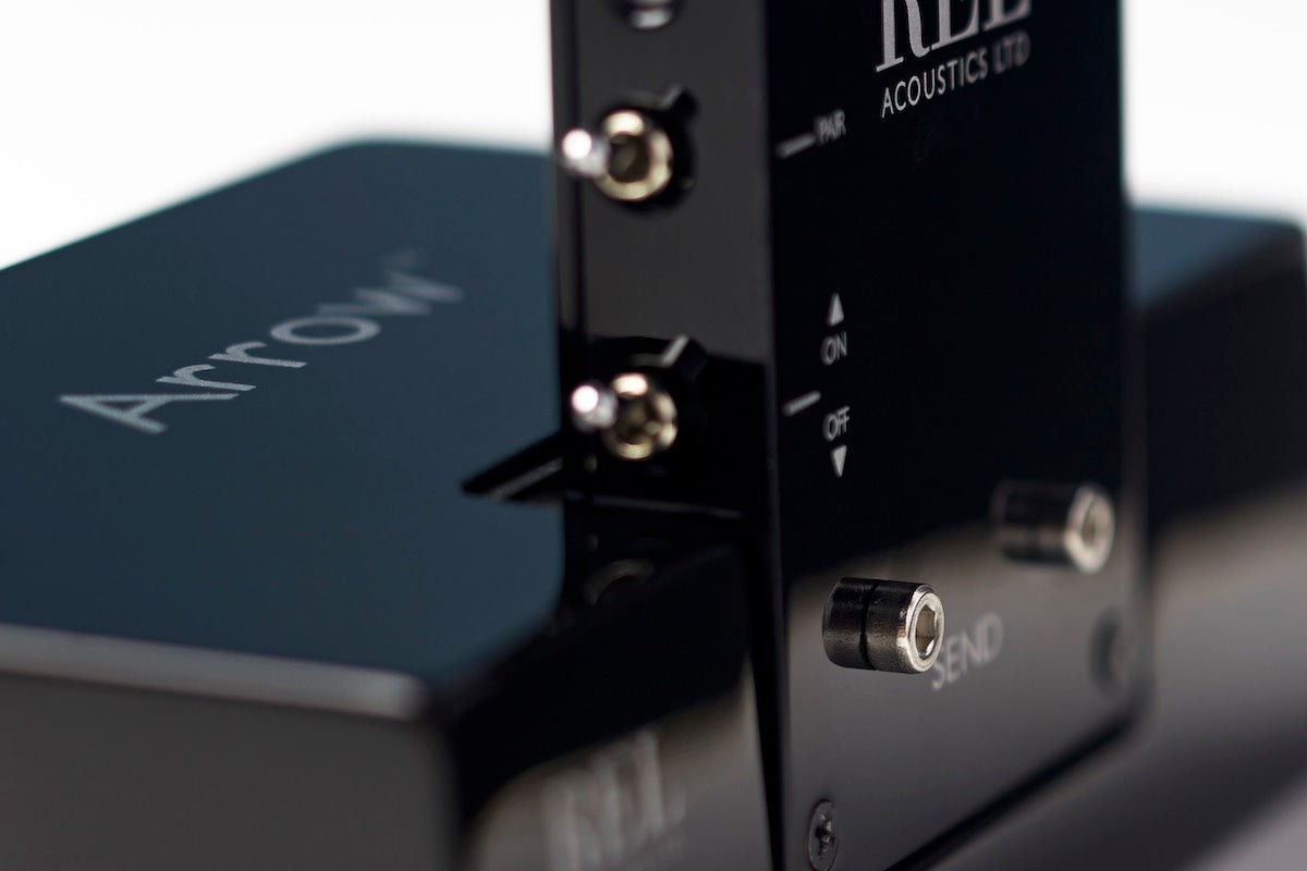 Gloss black transmitter engraved with its name, receiver blurred in the foreground
