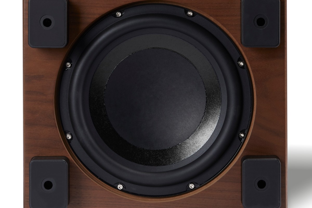 Paper-cone driver seen from below, between four black feet