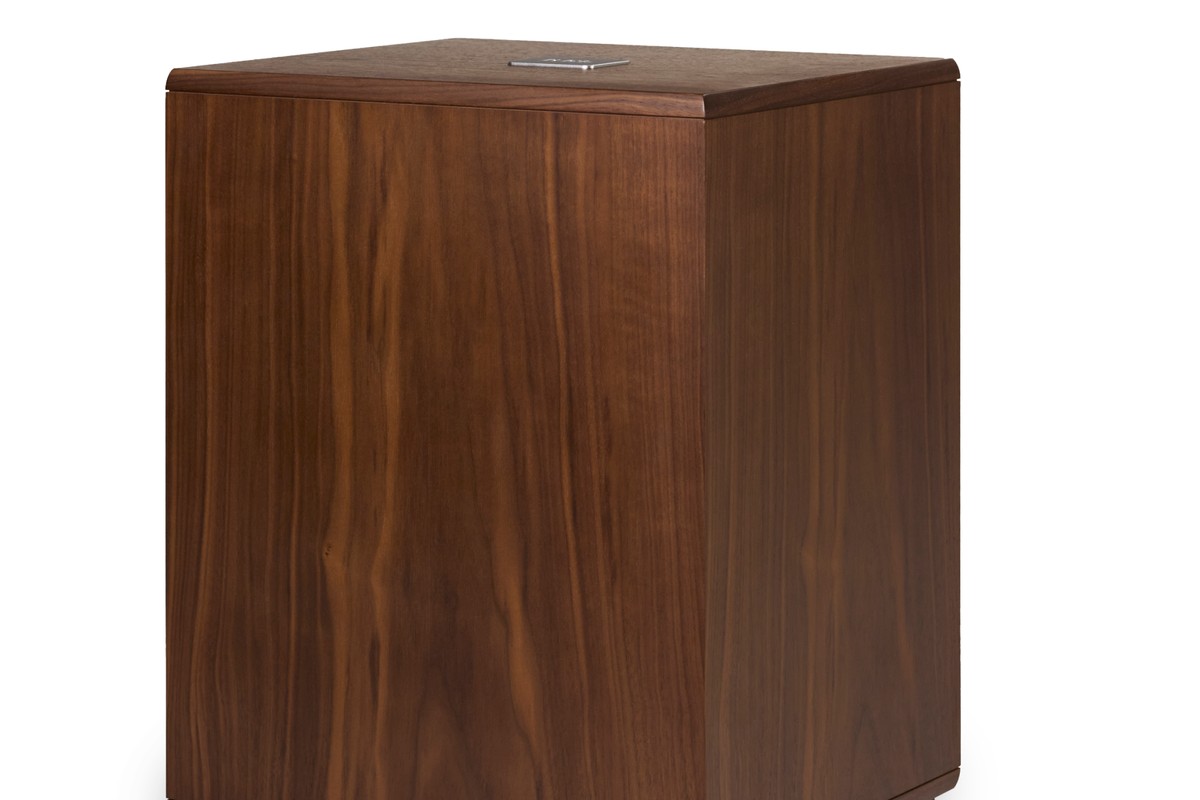 Walnut subwoofer at a three-quarter angle, showing the top and badge