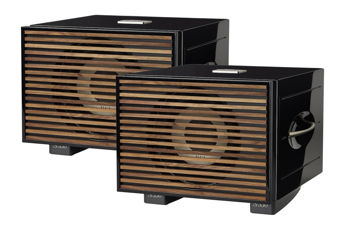 Zwei schwarze Subwoofer mit Holzabdeckungen, schräg von vorne