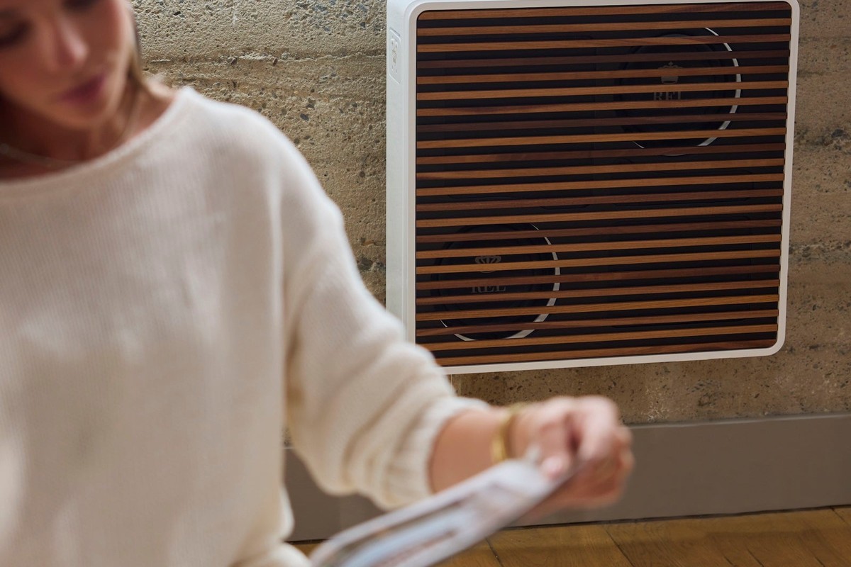 Subwoofer a parete con doghe in legno dietro una donna che sfoglia una rivista