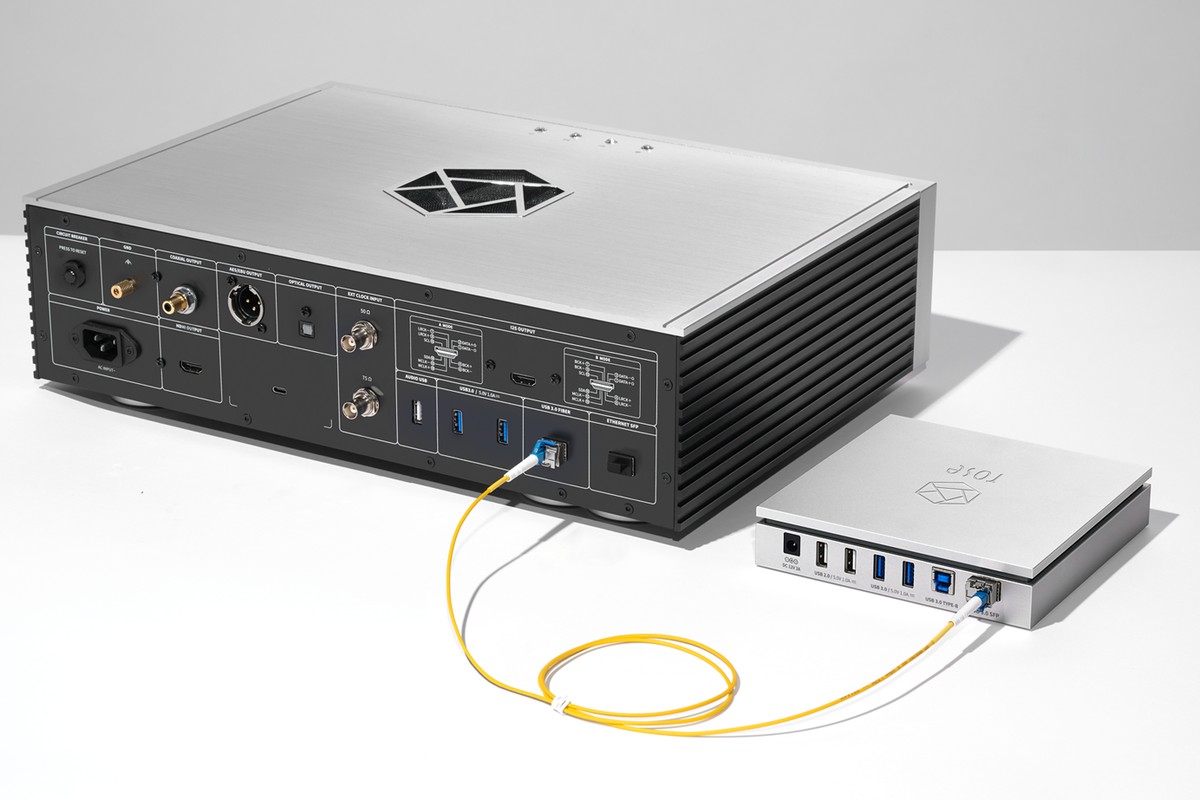 Hub USB relié par une fibre optique jaune à l'arrière d'un streamer argenté