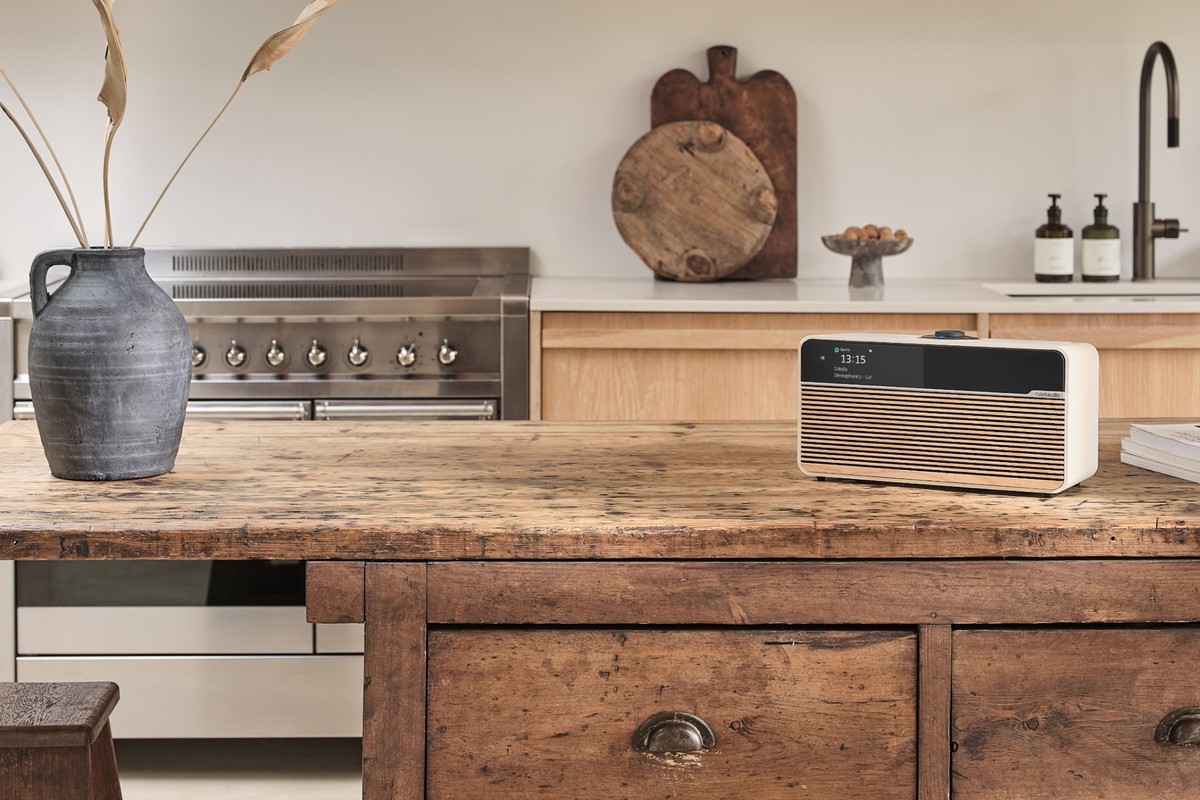 Ruark R2 Mk4 in finitura Light Cream con griglia Ash su un'isola da cucina in legno antico