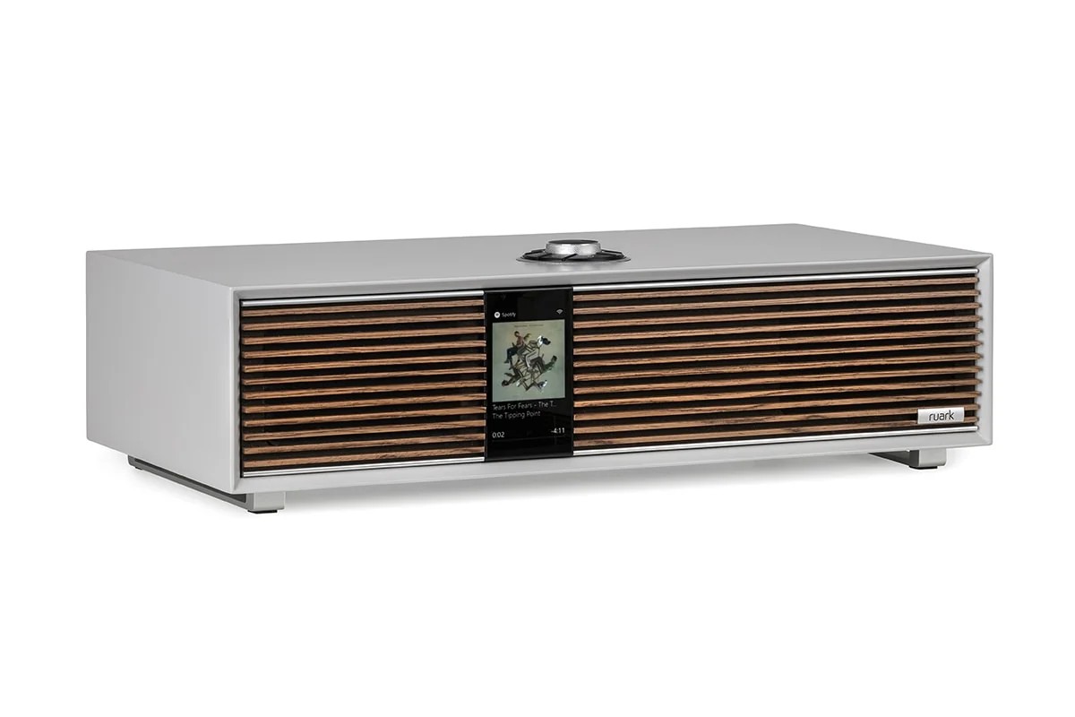 Three-quarter view of the light grey cabinet, walnut grille, colour screen and knob