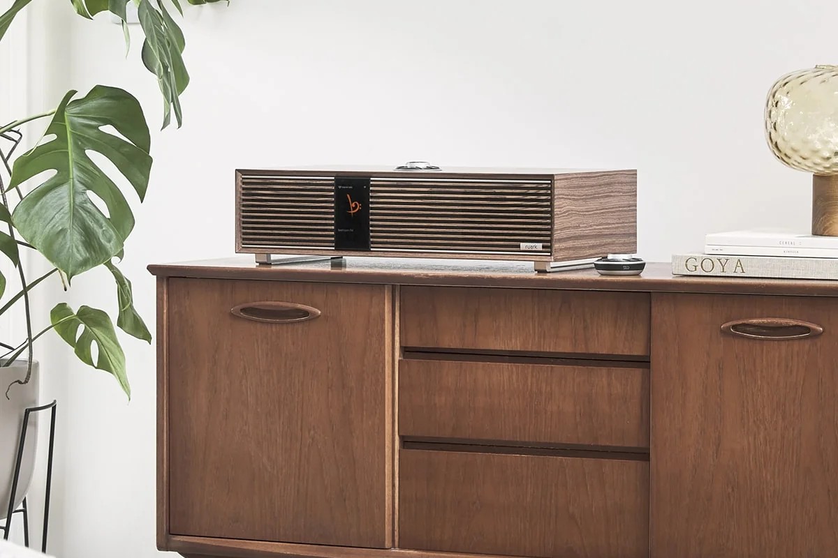 R410 Fused Walnut on a walnut sideboard, monstera and glass lamp beside it