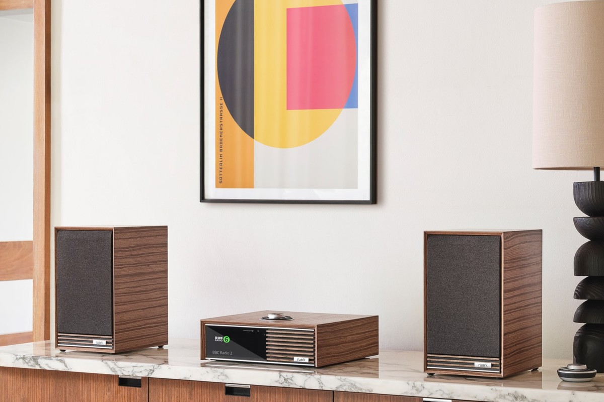 Pair of Sabre-R speakers with walnut veneer on either side of an R610, on a marble-topped sideboard