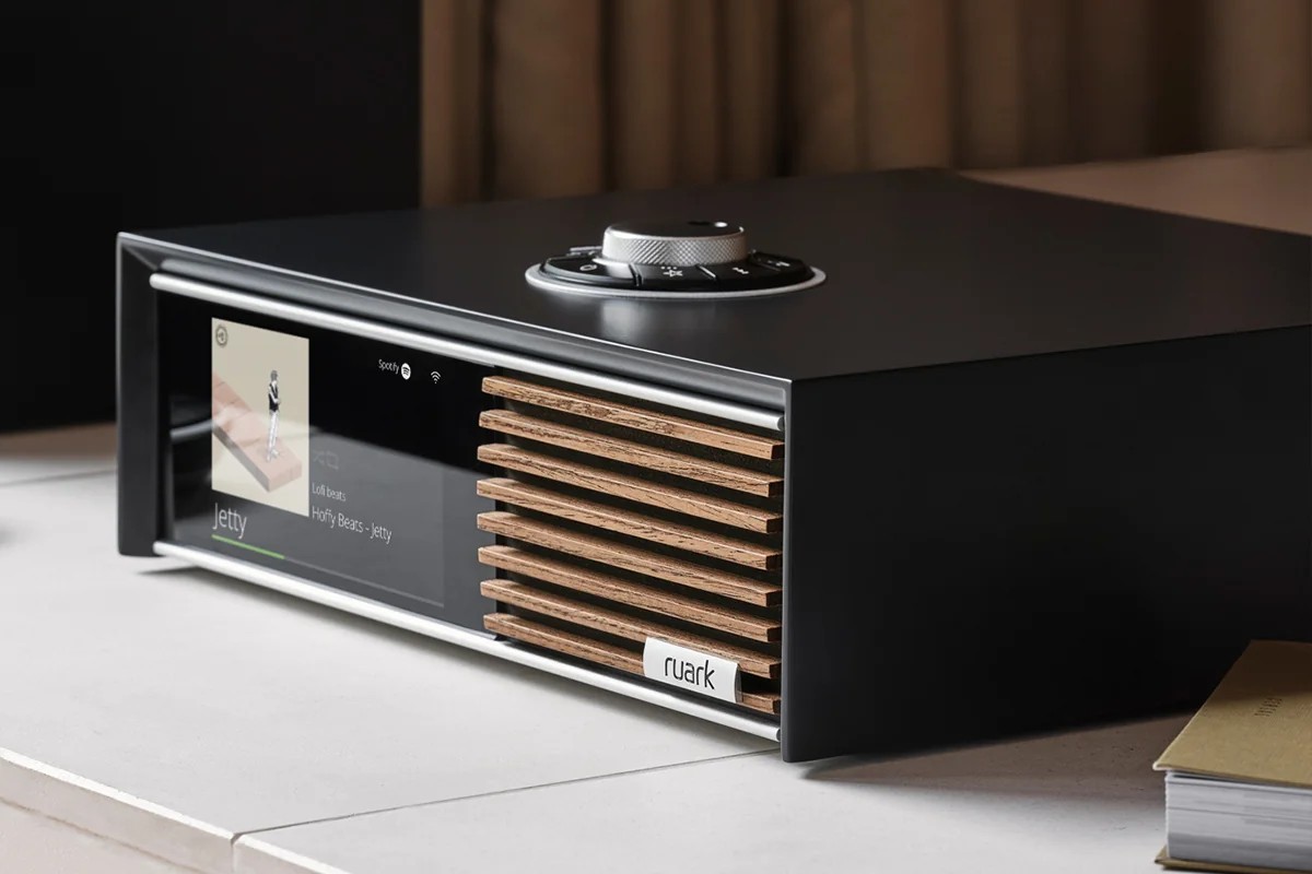 Ruark R610 laquée Satin Charcoal, façade noyer, gros plan sur un plan clair