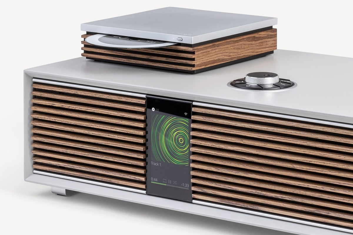 Lettore CD appoggiato su un apparecchio della serie 100 il cui display indica la sorgente CD