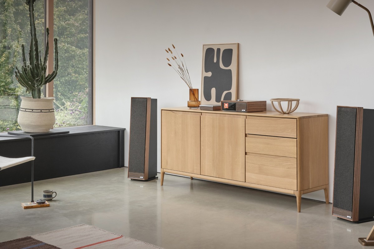 Floorstanding speakers either side of a sideboard, in front of a picture window